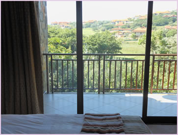 One of the bedrooms of 3 Baluwatu, with a beautiful view of the nearby Zimbali Golf Course and ocean